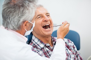 man getting his teeth checked by a dentist